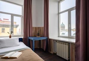 ein Schlafzimmer mit einem Bett und zwei Fenstern in der Unterkunft Отель РиверСайд Невский in Sankt Petersburg