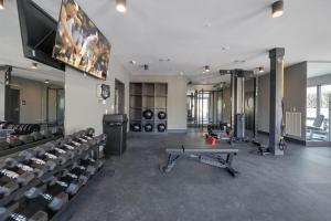 een kamer met een fitnessruimte met een tv en banken bij Vesta - Odyssey - Heart of Midtown in Nashville
