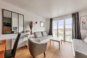 a living room with a couch and a table at Détente et vue sur le port à Arzon in Arzon