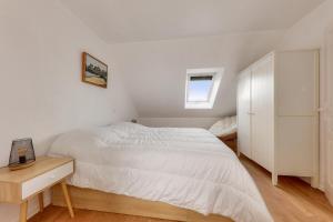a white bedroom with a bed and a night stand at Détente et vue sur le port à Arzon in Arzon +16 photos