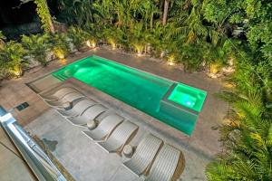- une vue sur la piscine dotée de chaises et de lumières dans l'établissement Tamiami Vice - 2327, à Sarasota