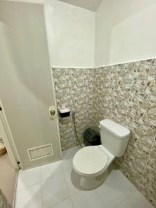 a bathroom with a white toilet in a room at TopBudz Hostel Panagsama Moalboal in Moalboal