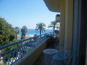 Un balcón con sillas y vistas al océano. en Apartment 2 chambres Palais HenriIV, en Niza