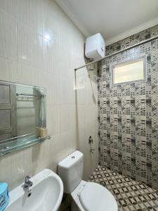 ein Bad mit einem WC und einem Waschbecken in der Unterkunft Villa Kelapa Gading Dalung in Dalung