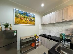 eine Küche mit einem Waschbecken und einem Gemälde an der Wand in der Unterkunft Villa Kelapa Gading Dalung in Dalung