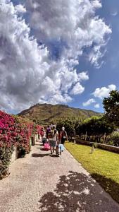 a group of people walking down a path with flowers at Case vacanze le Buganville in Ischia