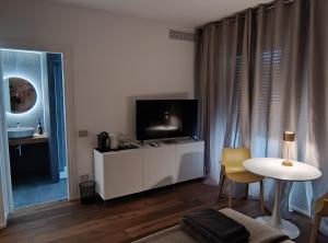 Residenze SiMari Luxury في بادوفا: غرفة معيشة مع تلفزيون وخزانة بيضاء