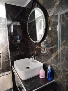a bathroom with a sink and a mirror at Christy's apartment by the sea in Skála Foúrkas +9 photos