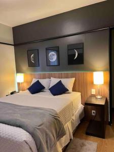 サンパウロにあるLa Residence Paulista - Flat 506 - Residence Service + Academia + Piscinaのベッドルーム(青い枕の大型ベッド1台付)