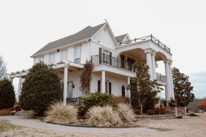 アセンズにあるTara Vineyard & Winery Estateのバルコニー付きの広い白い家