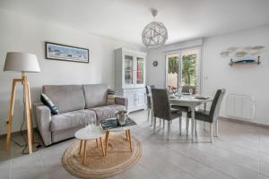 a living room with a couch and a table at Appartement dans résidence calme à 100m de la plage in Saint-Brévin-lʼOcéan