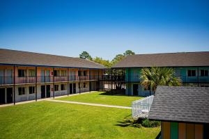 a school building with a lawn in front of it at Super 8 by Wyndham Biloxi in Biloxi