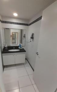 een witte badkamer met een wastafel en een spiegel bij Sonia Flats Natal - No Apart Hotel Ponta Negra Beach in Natal