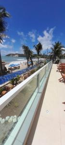 een loopbrug naast een strand met palmbomen bij Sonia Flats Natal - No Apart Hotel Ponta Negra Beach in Natal