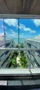 desde una ventana de un edificio con palmeras en Sonia Flats Natal - No Apart Hotel Ponta Negra Beach, en Natal