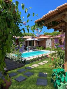 a garden with a swimming pool and a house at Vila Uryah in Caraíva