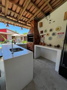 a kitchen with a sink and a stove at Vila Uryah in Caraíva
