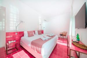 a bedroom with a large white bed with pink tiles at Hotel Villa Durrueli Resort & Spa in Ischia
