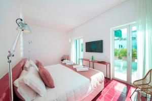a white bedroom with a bed and a balcony at Hotel Villa Durrueli Resort & Spa in Ischia