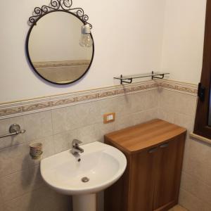 een badkamer met een wastafel en een spiegel bij La casa di Andrea in Terrasini +25 foto's