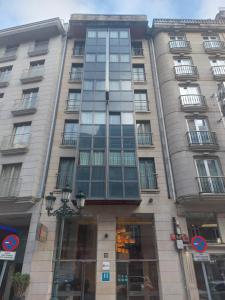 un edificio alto con ventanas en una calle de la ciudad en U Hotel Ogalia Vigo, en Vigo