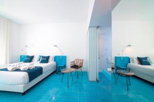 a bedroom with blue floors and a bed and a couch at Hotel Villa Durrueli Resort & Spa in Ischia
