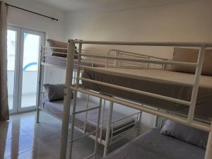 two bunk beds in a room with a window at HostelCCPortimão in Portimão