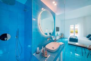a blue bathroom with a sink and a mirror at Hotel Villa Durrueli Resort & Spa in Ischia