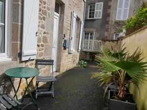 a small alley with a table and chairs in front of a building at Les Gravelots in Saint-Vaast-la-Hougue