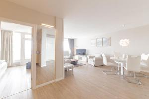 ティメンドルファー・シュトラントにあるFerienwohnung Residenz App. 911の白い家具のあるリビングルームとダイニングルーム