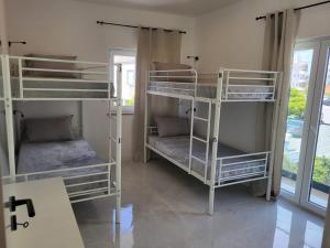 2 łóżka piętrowe w pokoju z oknem w obiekcie HostelCCPortimão w mieście Portimão