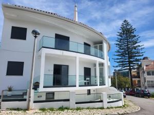 a white building with a balcony on the side of it at HostelCCPortimão in Portimão