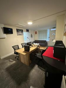 um escritório com uma secretária, cadeiras e um sofá em Macclesfield Lodge em Macclesfield