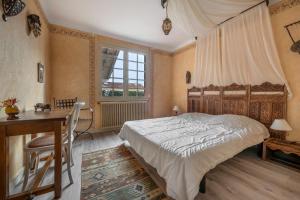 a bedroom with a bed and a desk and a window at Maison pour 8 - proche plages in Mindin