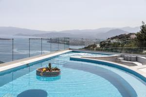 a large swimming pool with a view of the ocean at Villa Marianna in Agios Nikolaos