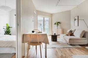 1 dormitorio con cama, mesa y sofá en Central City Apartment, en Bergen