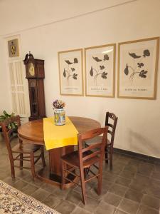 a dining room with a table and chairs and a clock at B&B Loft Famiglia Arezzo in Ragusa
