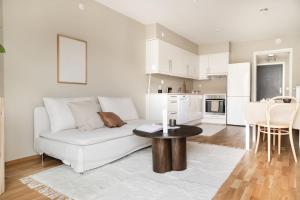 a living room with a white couch and a table at Central City Apartment in Bergen