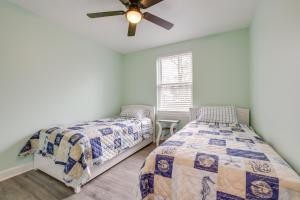 een slaapkamer met twee bedden en een plafondventilator bij Angola Vacation Rental, Walk to Lake Erie Beach! in Angola-on-the-Lake