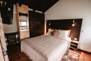 a bedroom with a large bed and a television at All Suite El Marques de Antigua in Antigua Guatemala