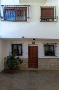 un edificio blanco con tres ventanas y una puerta en Dúplex FAJALAUZA ALBAICÍN, en Granada
