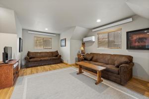 uma sala de estar com dois sofás castanhos e uma televisão em Black Hills Trailside Park Resort em Hill City