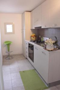 a kitchen with a stove and a bowl of fruit at B&B Loft Famiglia Arezzo in Ragusa