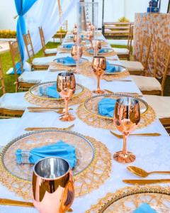 długi stół z talerzami i kieliszkami do wina w obiekcie Sofitel 3 bedrooms own compound Mamboleo w mieście Kisumu