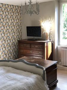 a bedroom with a dresser with a tv on top at Maison avec vue sur le Vercors in Beauregard-Baret