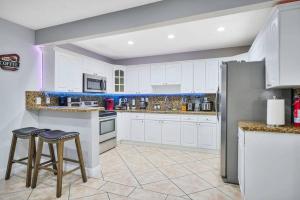 eine Küche mit weißen Schränken und 2 Barhockern in der Unterkunft Escape GameRoom, BAR, BBQ, Spacious,KING Bed, All Luxury mattresses, Near Beach, 6 blocks away from Bars, Nite Clubs, Res, Shops in Miami + 67 Fotos