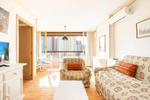ein Wohnzimmer mit einem Sofa und einem Tisch in der Unterkunft Acuarium III-2-F Apartment Levante Beach in Benidorm