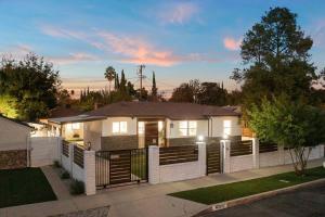 een wit huis met een hek ervoor bij ৎ୭ Luxury Reseda with Pool ৎ୭ in Los Angeles