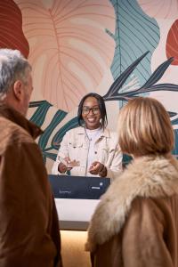 a woman standing in front of a table with a laptop at The Nici in Bournemouth