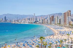 ein Strand mit Sonnenschirmen und das Meer und eine Stadt in der Unterkunft Acuarium III-2-F Apartment Levante Beach in Benidorm